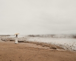 A young women with an umbrella near the Geysir Geothermal Area in Iceland